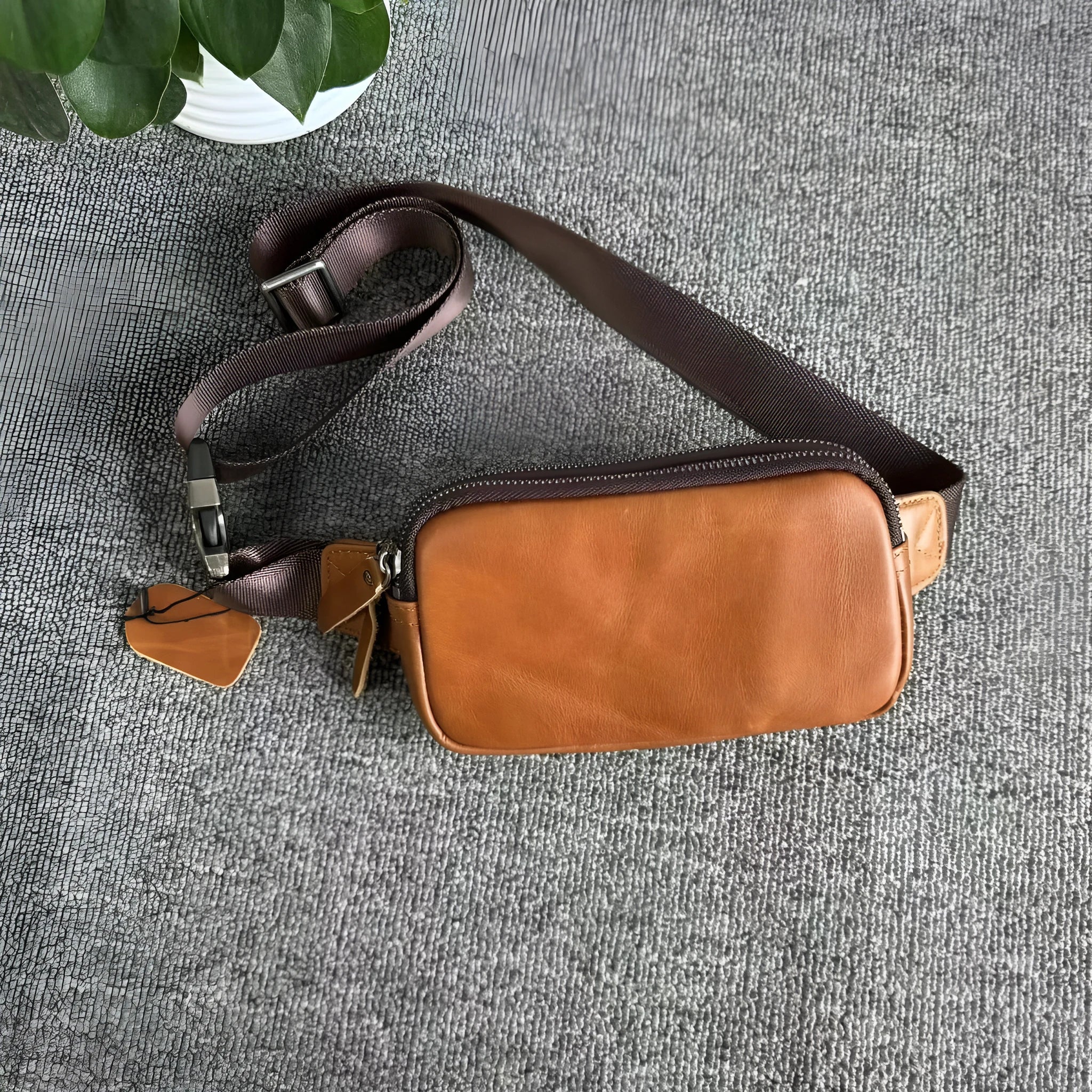 Men's small leather crossbody bag in cowhide showing compact dimensions and urban simplicity styling