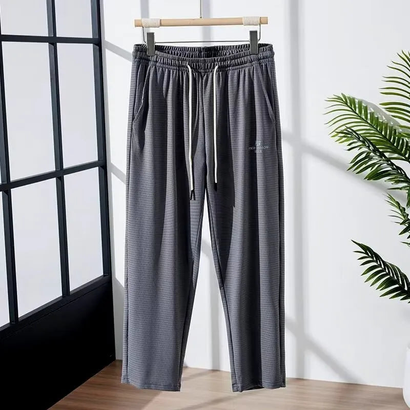 Men's loose straight-leg trousers with elastic mesh panels and ankle tie in black ice silk fabric