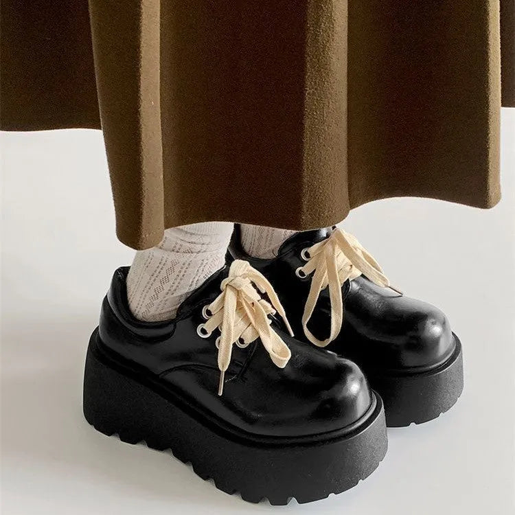 Women's matte black lace-up shoes with a 6-8cm English muffin heel and round toe on a solid background