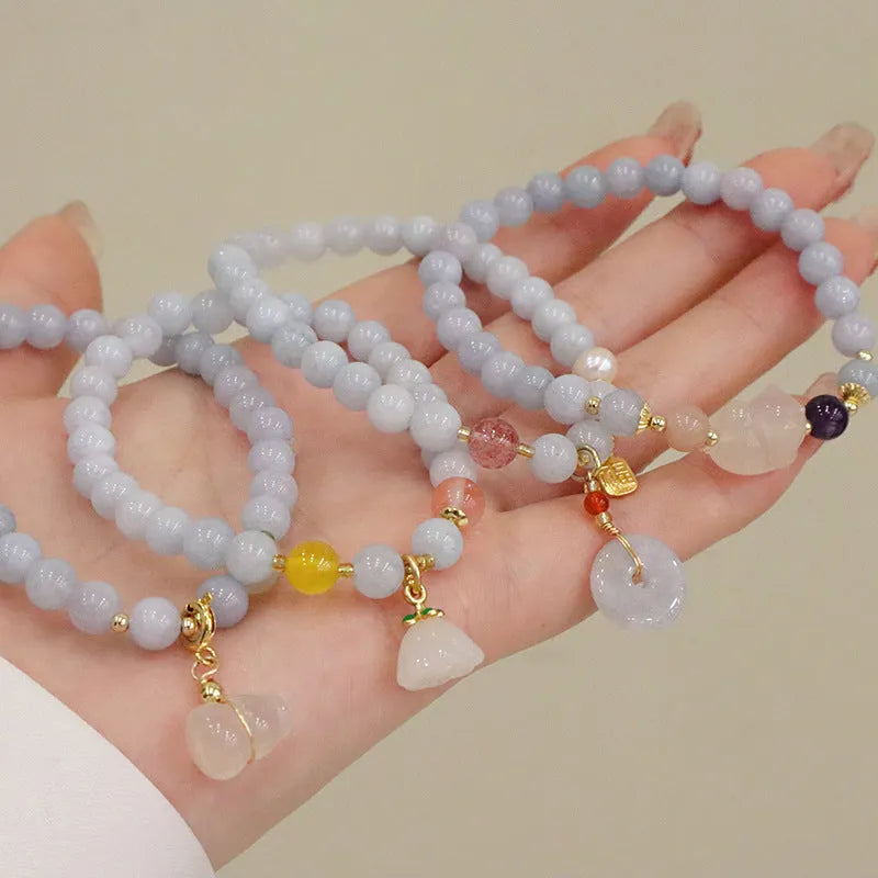 Women's gold plated crystal bracelet with aquamarine chalcedony charm on wrist