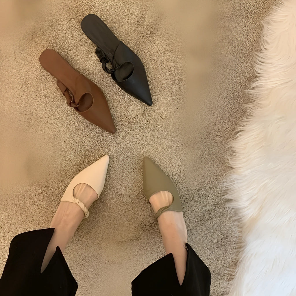 Women's soft leather semi-toe box slippers in black with a rubber sole, shown from the side.