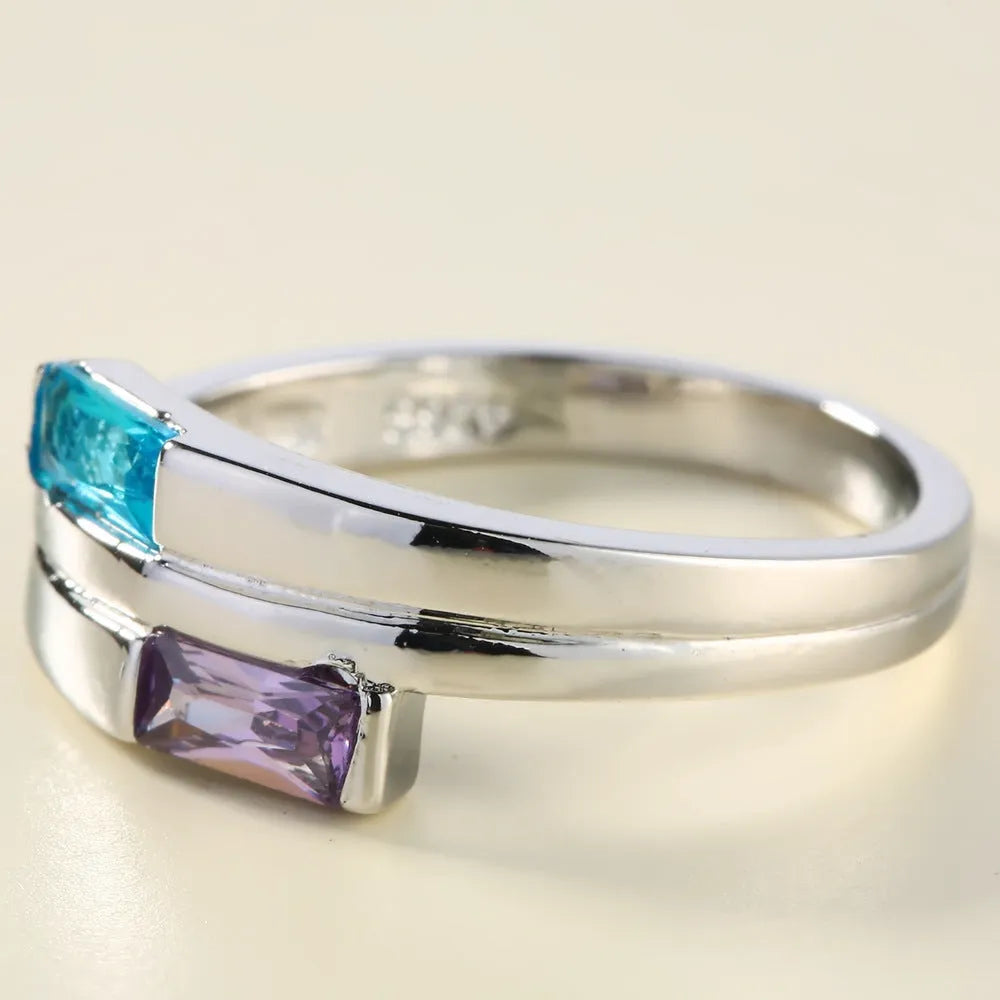 Silver-coloured copper ring with a central zircon stone, shown on a hand.