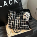 Black woolen shoulder bag with horizontal square shape showing internal organisation compartments