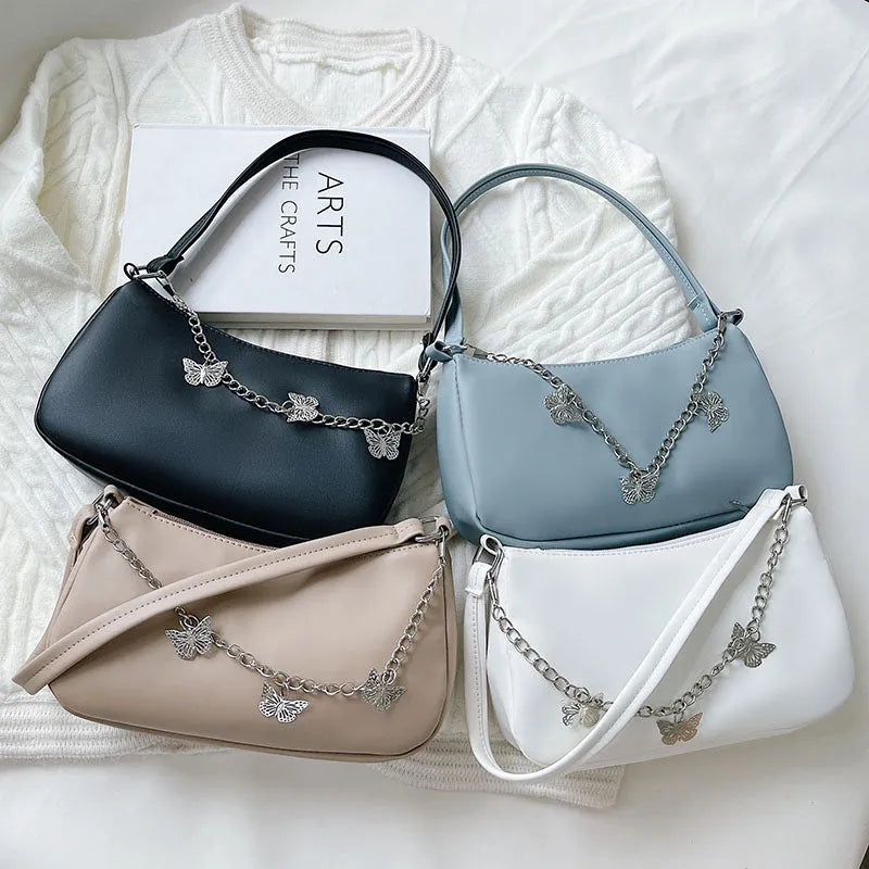 Black butterfly chain underarm bag showing three-dimensional pocket and adjustable metal chain strap