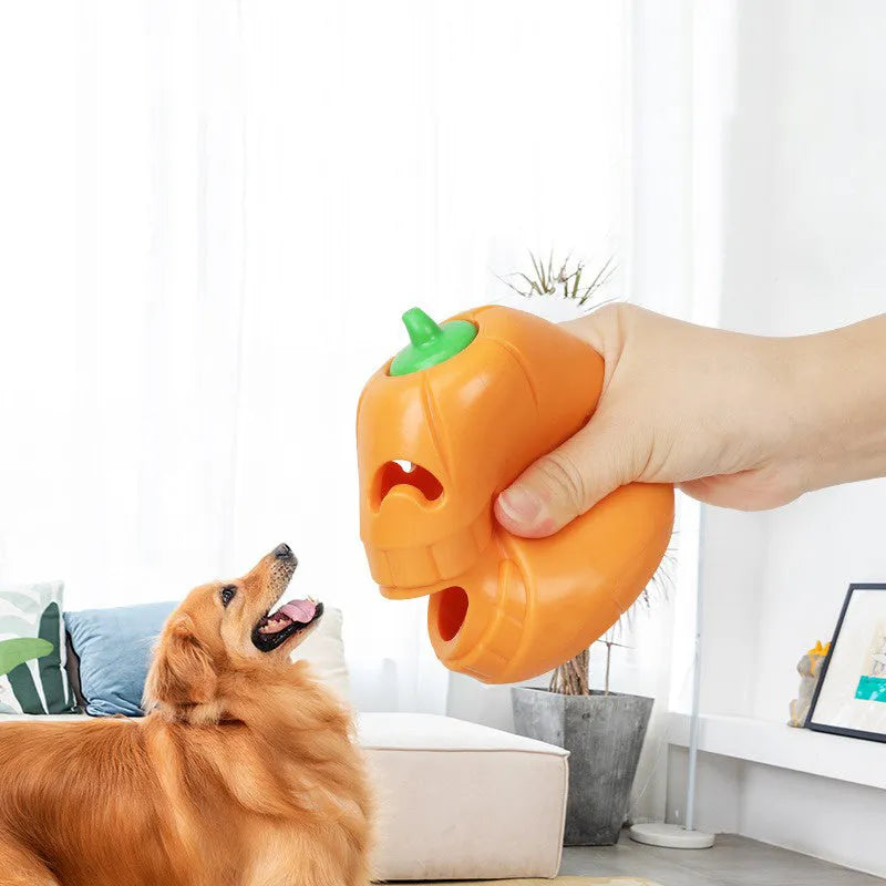 Orange Halloween pumpkin-shaped dog chew toy with treat-dispensing openings and textured surface