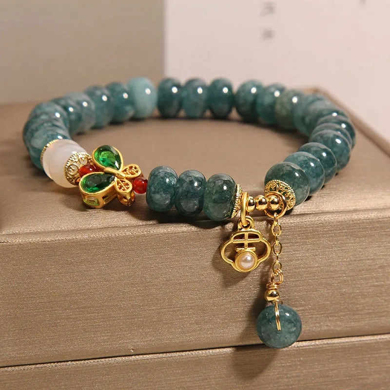 Women's blue water jade abacus bead crystal bracelet with butterfly charm and white agate accents