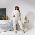 Women's milky white plush two-piece set with crew neck top and full-length pants on hanger