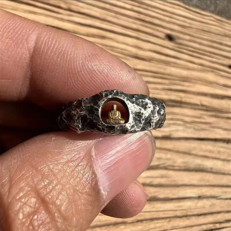 Hand-forged copper ring with rock texture surface and Buddha element, showing hammer marks and matte finish