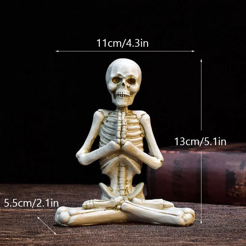 Hand-painted resin yoga pose skull skeleton ornament measuring 10.5-11cm wide on wooden desktop