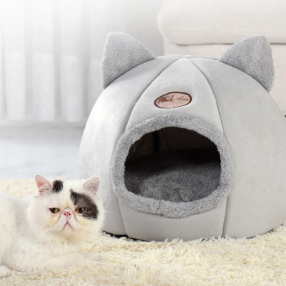 Large fully enclosed fabric cat house with a single entrance, shown in a home setting.