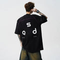 Men's loose fit black cotton T-shirt with a printed letter design on the front.