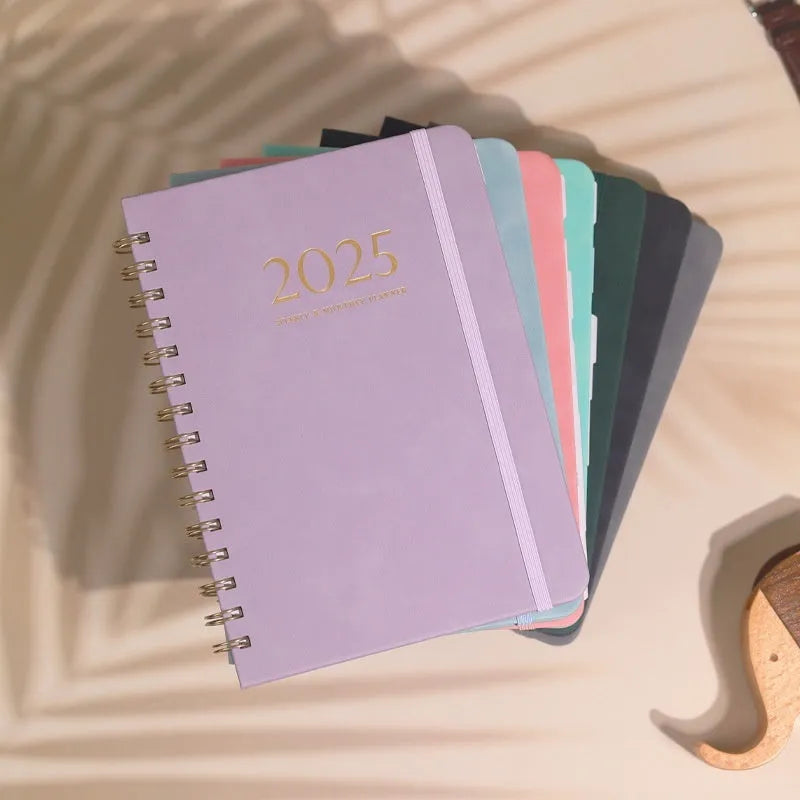 A5 size PU leather notebook with metal coil binding, shown in a choice of cover colours including black, brown, blue, and pink.
