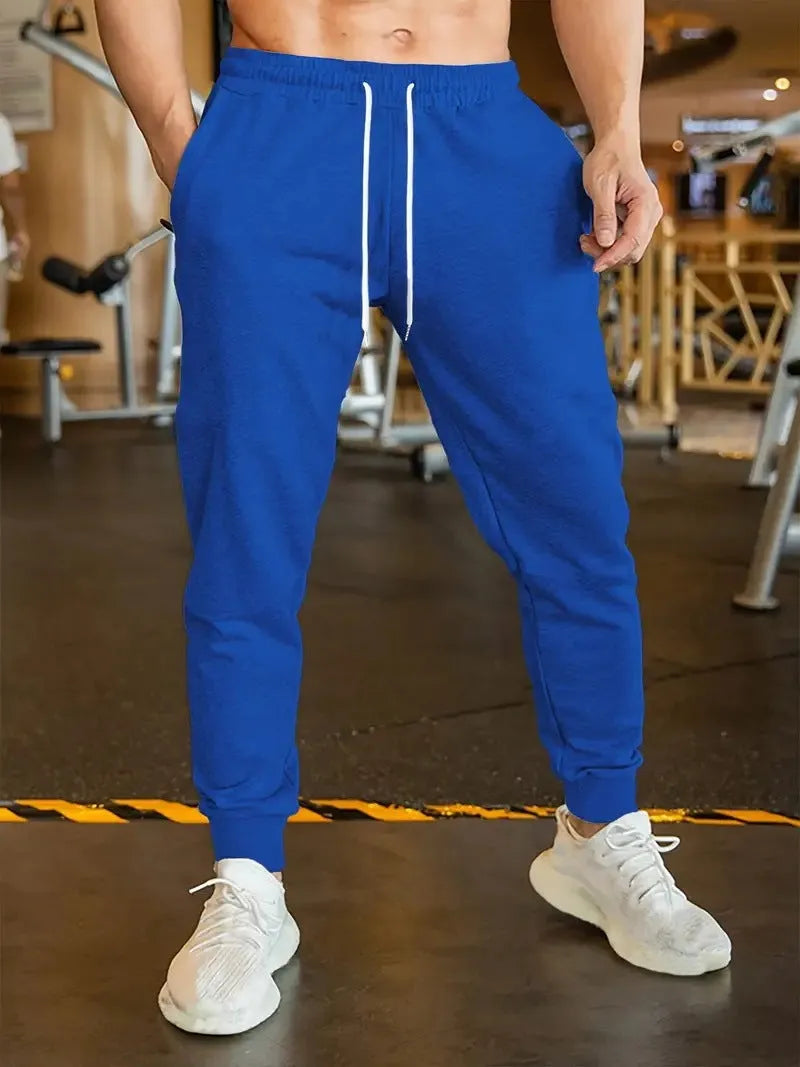 Men's beige loose-fit leisure trousers with an elastic drawstring waist and a thin 3D pattern fabric.