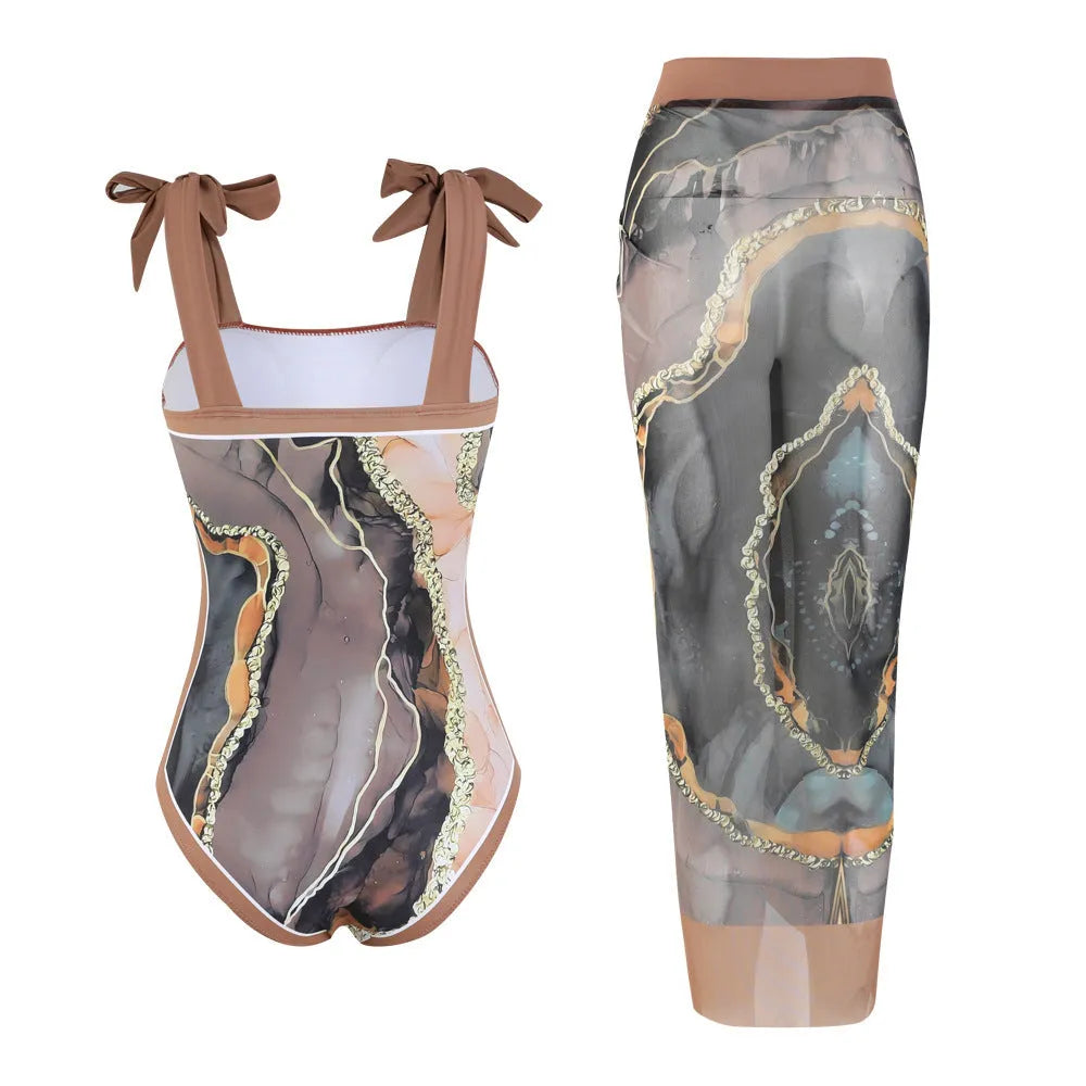 Floral print one-piece swimsuit with mesh tube top and a matching detachable skirt laid flat.