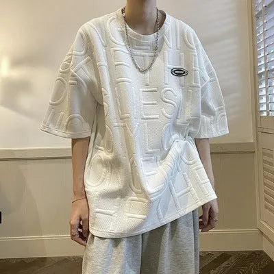 Men's grey T-shirt with raised black letters, loose fit, short sleeves, on a hanger