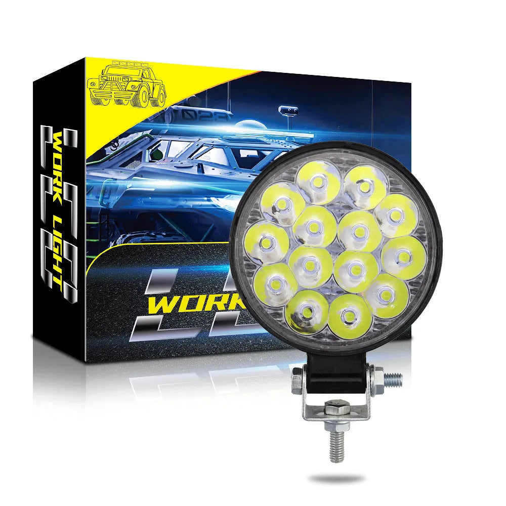 White mini round aluminium LED work light with IP67 rating for vehicle use.