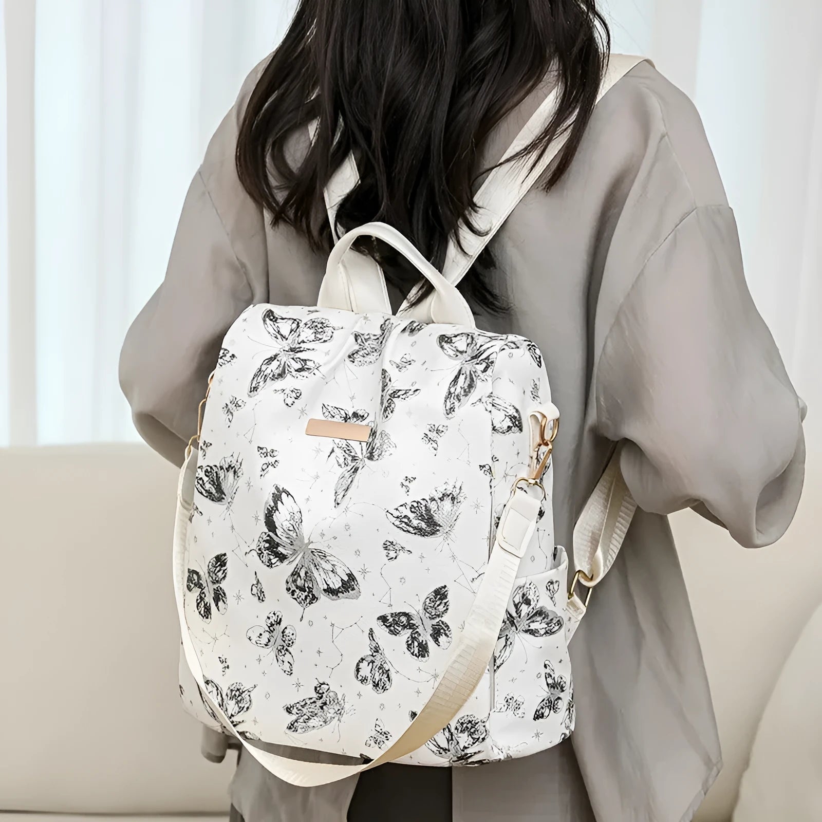 Butterfly printed black PU leather backpack with visible sewing lines and a physiological curve backplate.