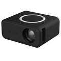 Black YT300 portable mini projector on a table, projecting a movie scene onto a wall.