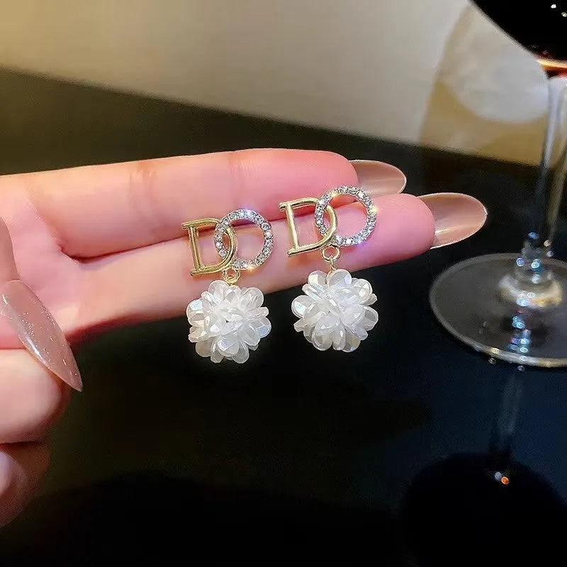 White DO letter embroidered ball earrings for women, trendy drop style with letter and ball detail.