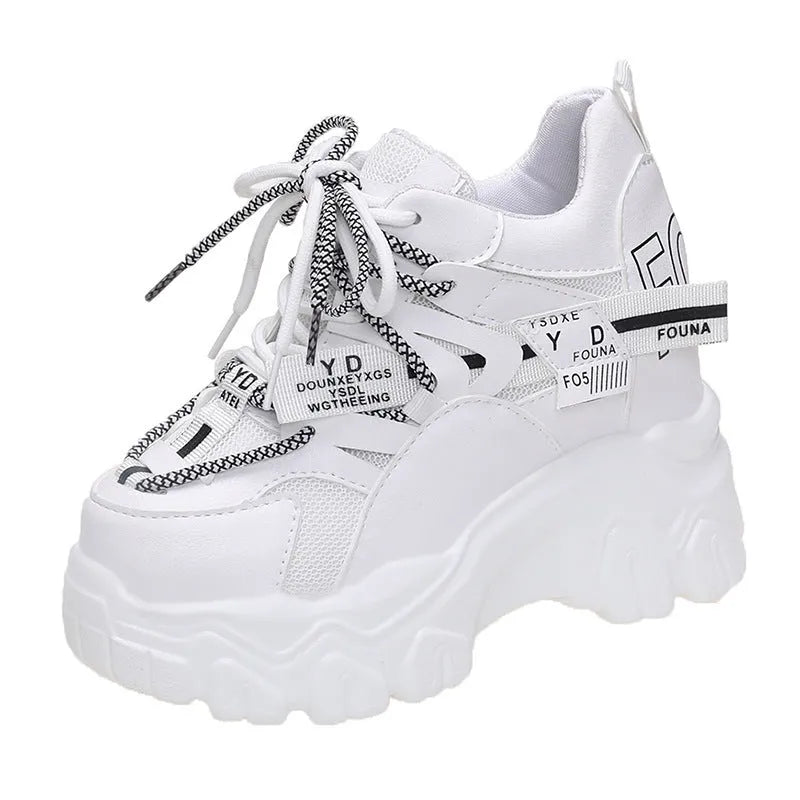 Women's white low-top platform sports shoes with cross strap and rubber sole on a light background