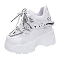 Women's white low-top platform sports shoes with cross strap and rubber sole on a light background