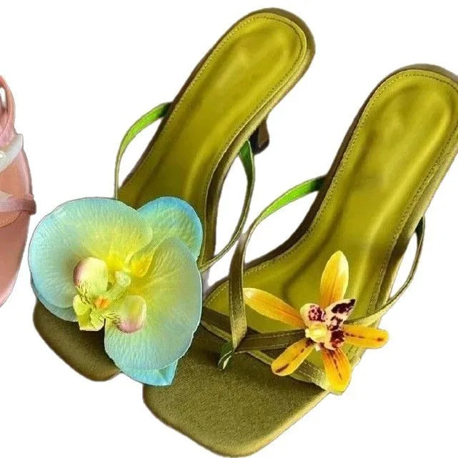 Handmade women's high-heel sandals with square toe and asymmetric floral decoration on calf leather.