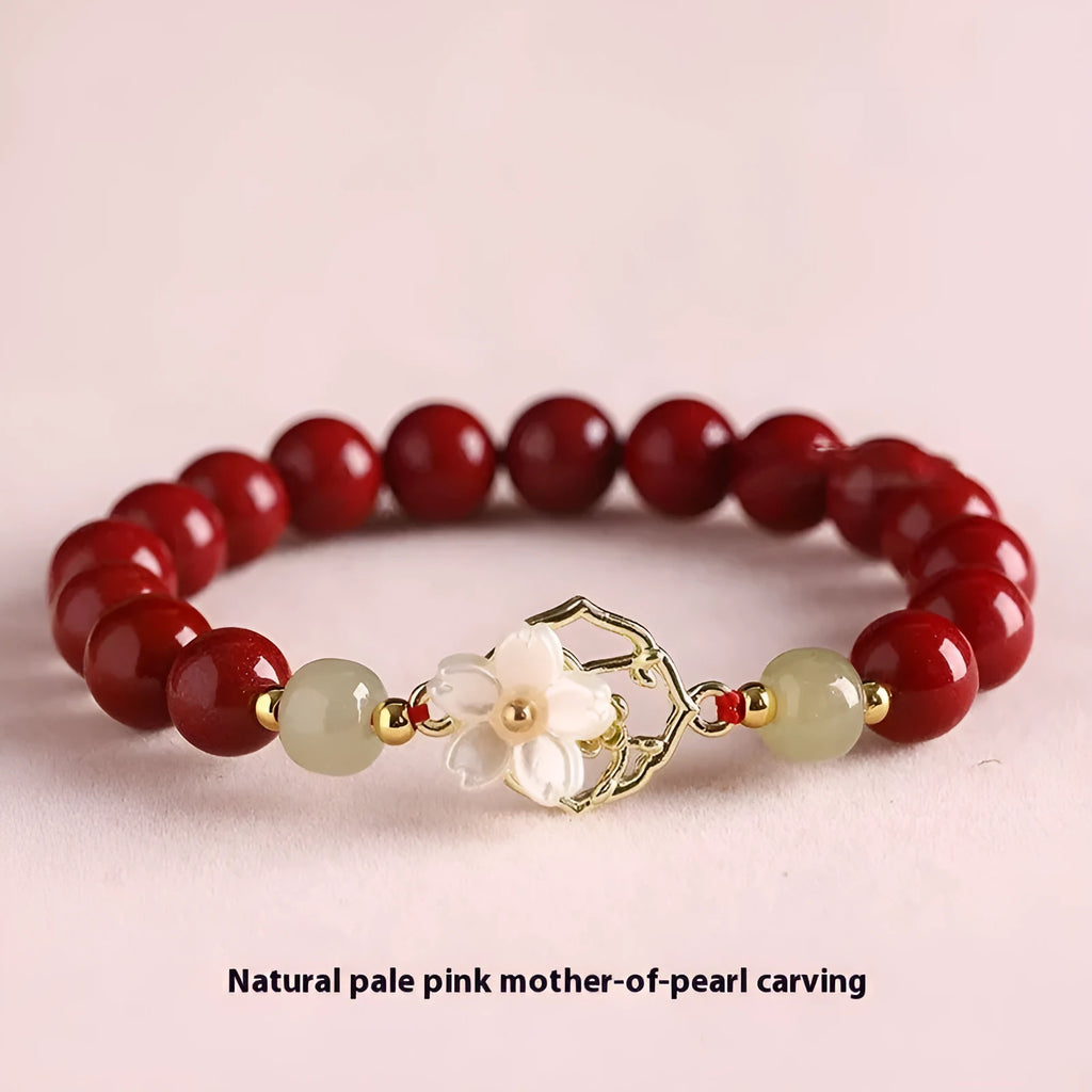 Handcrafted cinnabar bracelet with white Hetian jade butterfly charm, Bells of Ireland, and lotus details in New Chinese style.