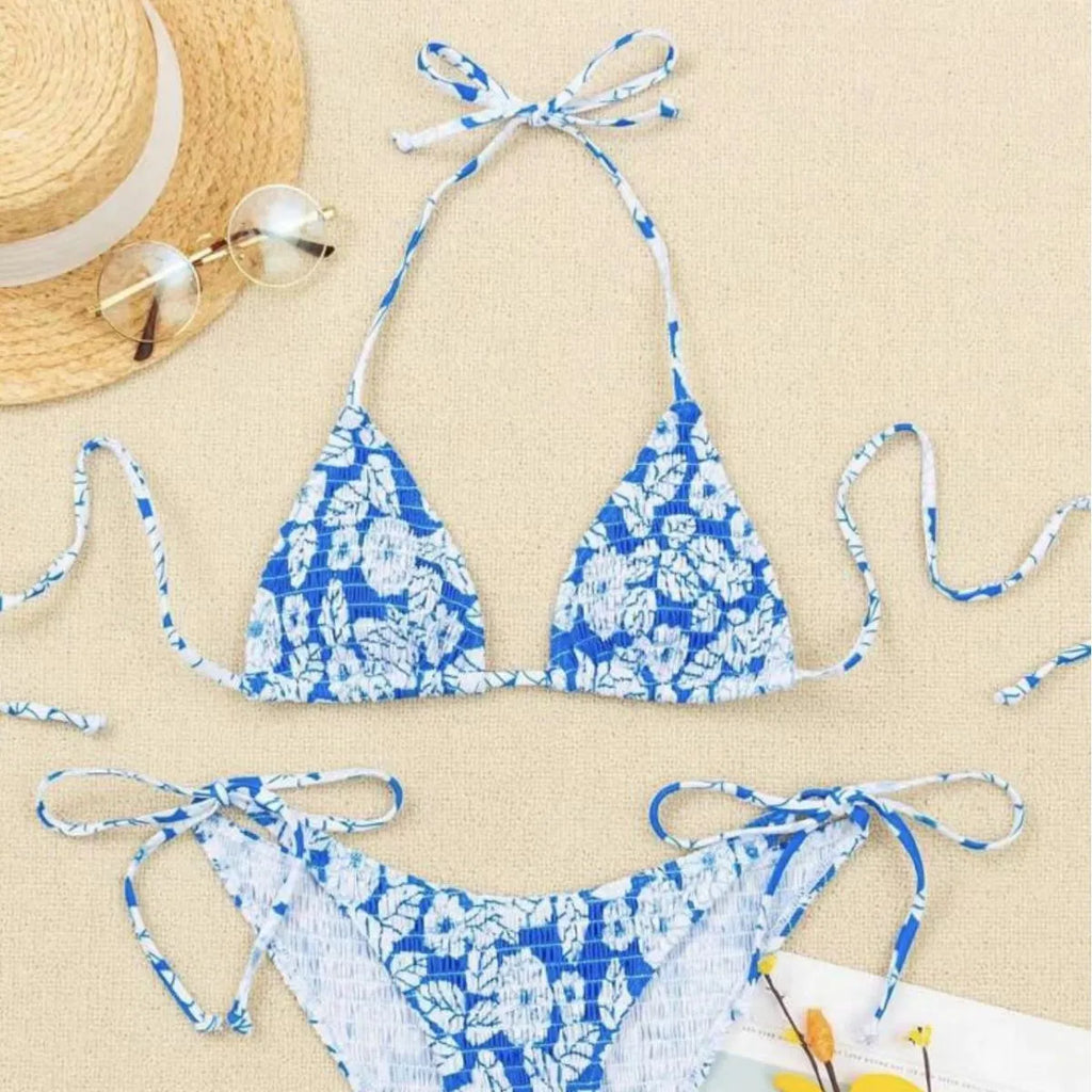 Women's floral halter swimsuit one-piece in light blue polyester on a mannequin