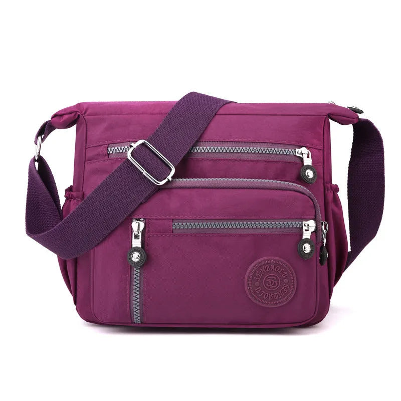 Nylon messenger bag in dark blue with single shoulder strap and soft square design, showing lining cloth interior.