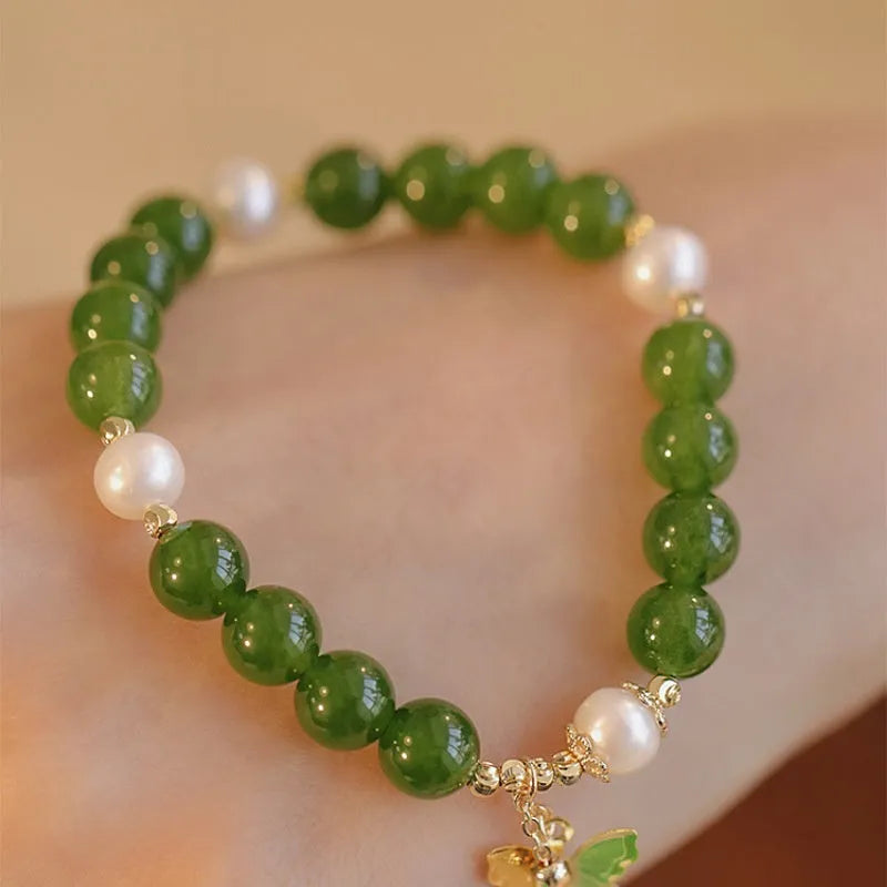 Green chalcedony bracelet with geometric round beads on a wrist.