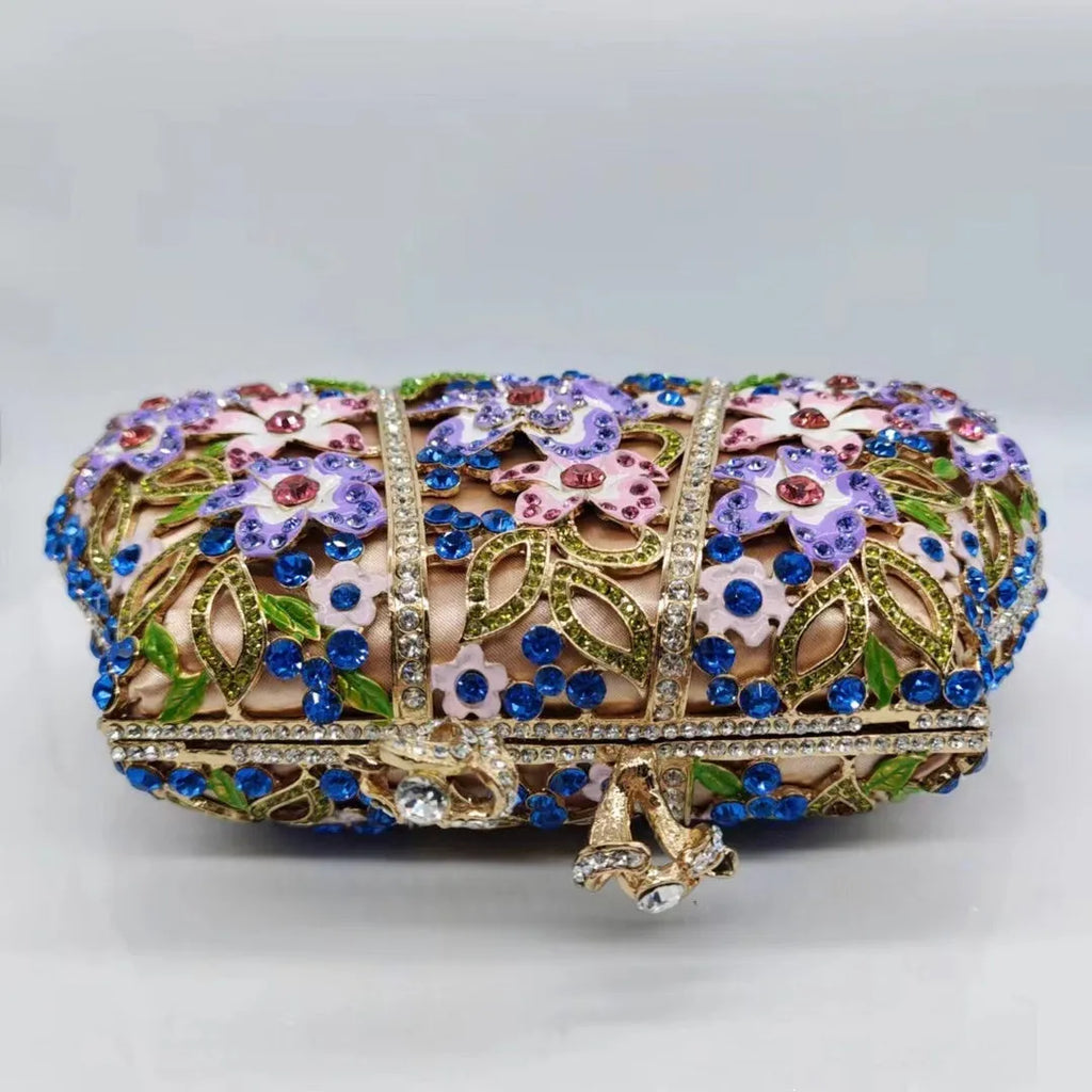 Gold oval metal evening clutch with enamel flower, hollow, diamond and dripping oil detail, 22cm long