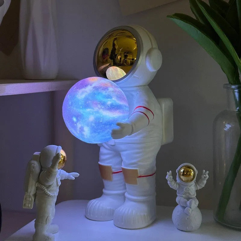 Spaceman-themed starry sky projection lamp with Bluetooth speaker on a bedside table.