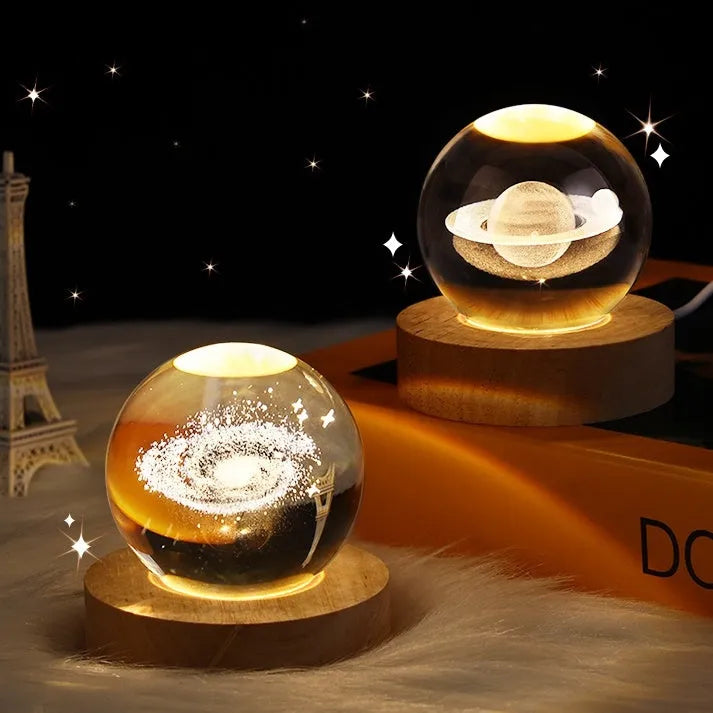 3D crystal ball night light projecting starry sky and planets from its 6cm sphere on a solid wood base.
