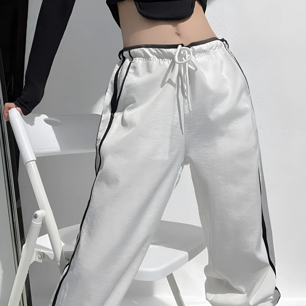 Women's loose straight-leg trousers with ribbon contrast detail in white and navy blue.