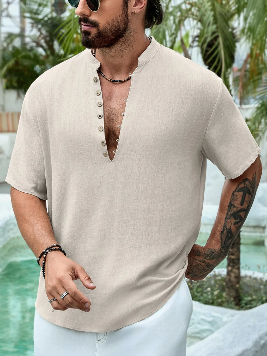 Man wearing a deep V-neck short sleeve casual shirt in a solid colour.