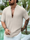 Man wearing a deep V-neck short sleeve casual shirt in a solid colour.