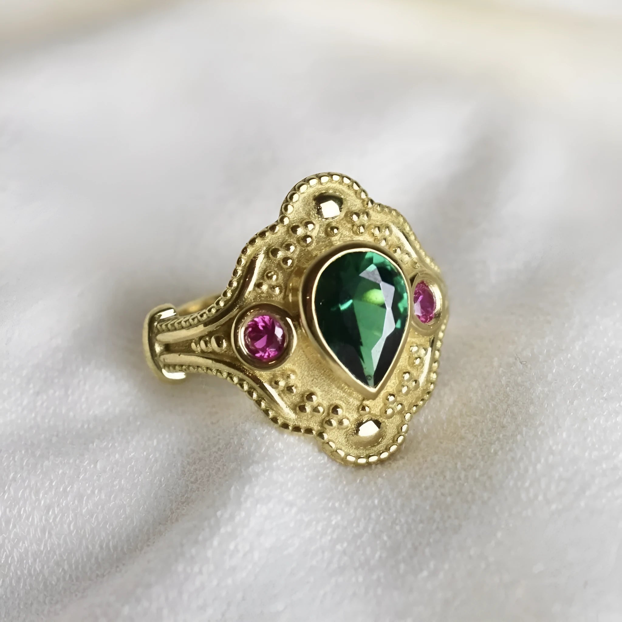 Gold-plated geometric fashion ring for women on grey background showing detailed design