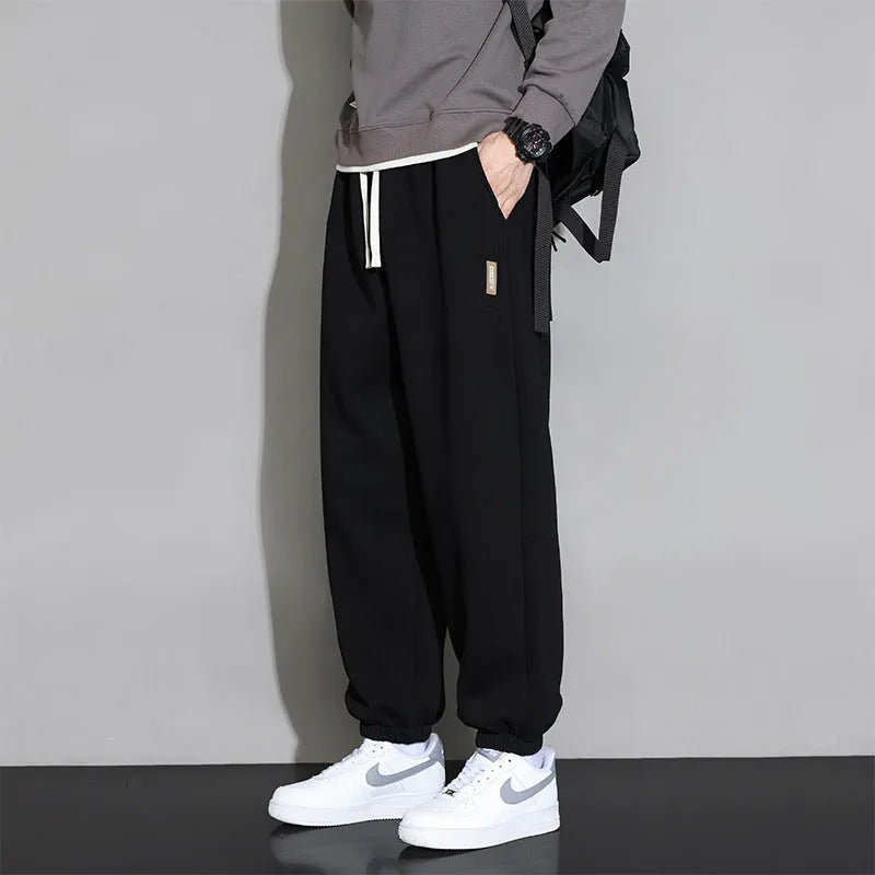 Men's loose grey cotton sports trousers with elastic waistband on hanger