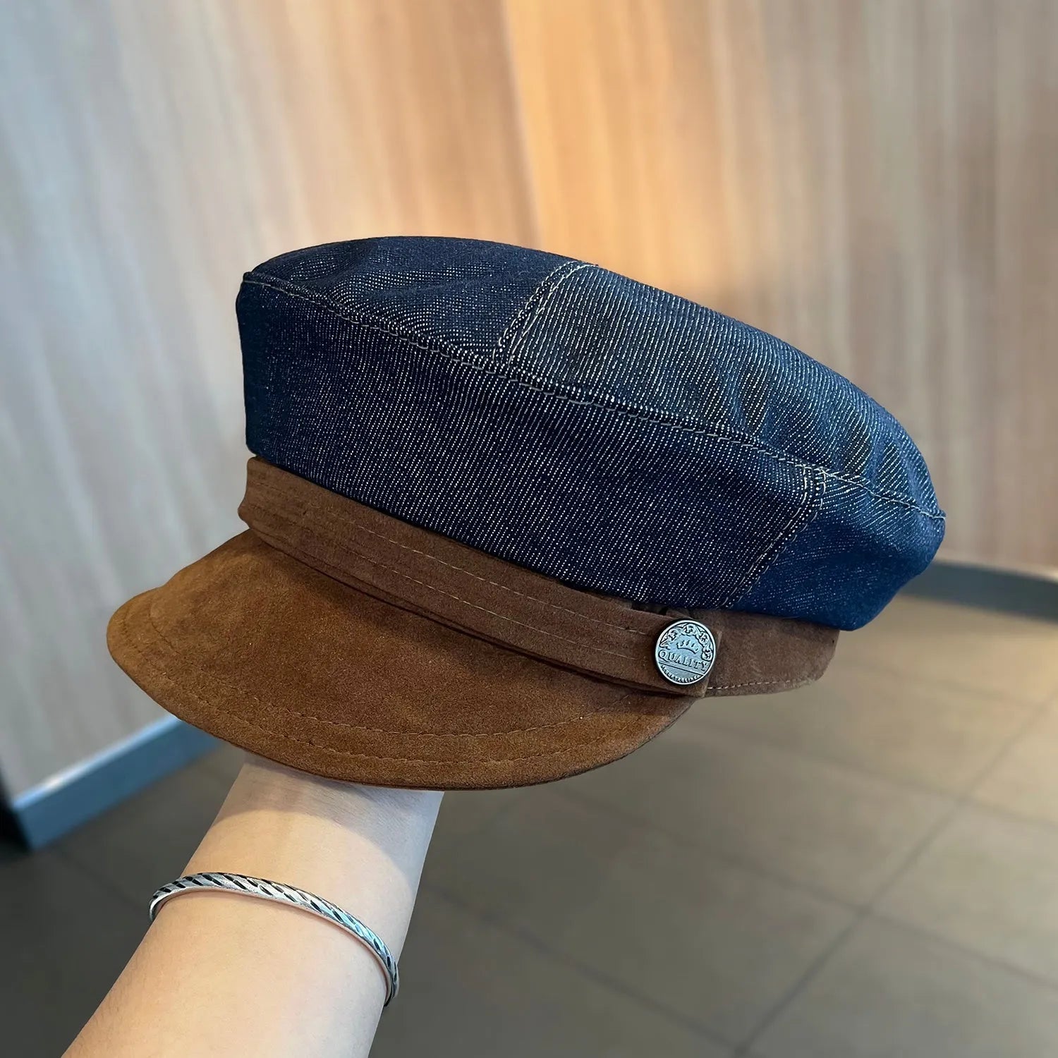 Dark blue denim British retro octagonal newsboy cap with an adjustable strap and coloured brim option on display.