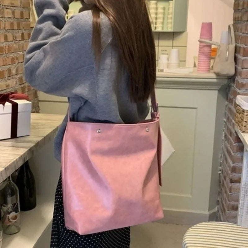 Pink corduroy one-shoulder commuter bag showing size and texture