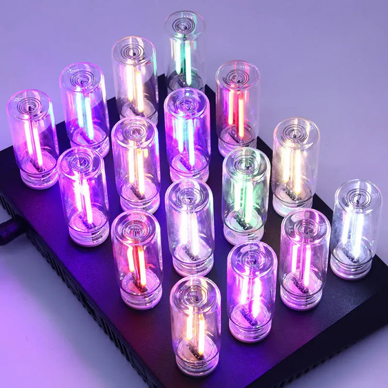 Small transparent glass USB touch night lamp with platinum base on a surface, showing warm white glow.