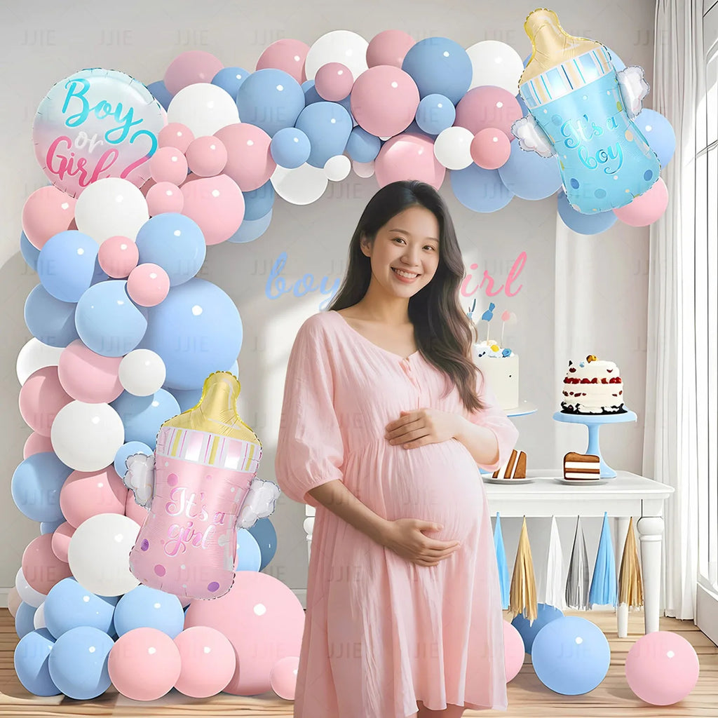 Gender reveal balloon decoration kit with pink and blue aluminium foil balloons, ribbon, and bottles.
