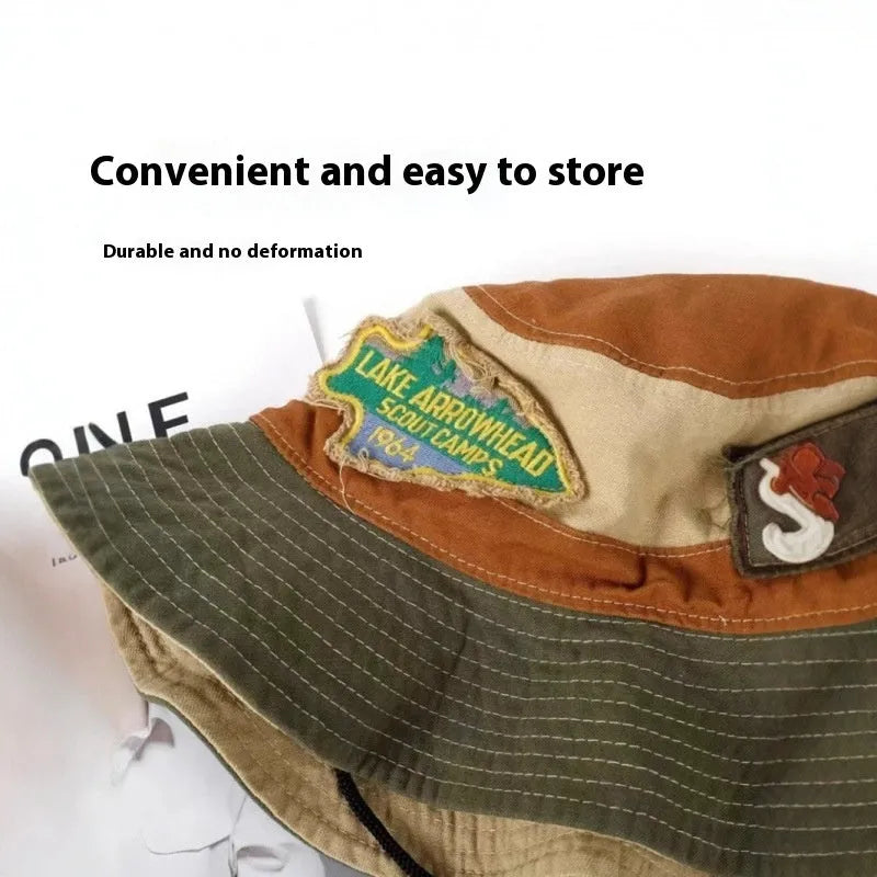 Army green cotton fisherman hat with hand-painted patchwork on flat top crown, folded for storage