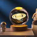 3D crystal ball night light projecting starry sky and planets from its 6cm sphere on a solid wood base.