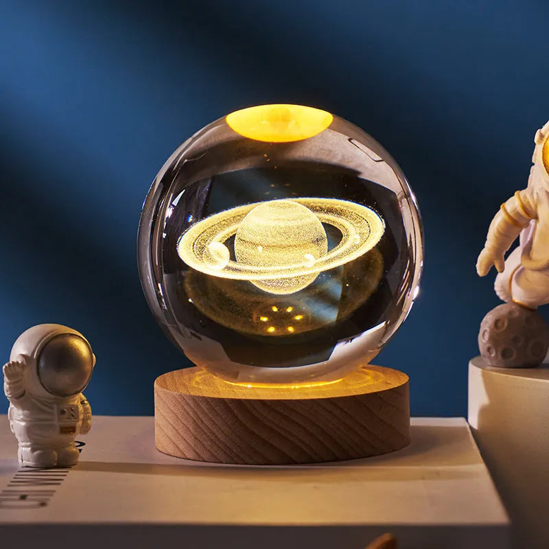 3D crystal ball night light projecting starry sky and planets from its 6cm sphere on a solid wood base.