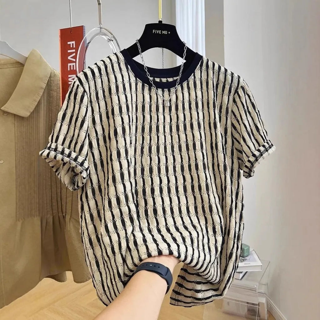 Men's black striped short-sleeve shirt with loose fit, made from linen and silk blend, shown in casual wear.