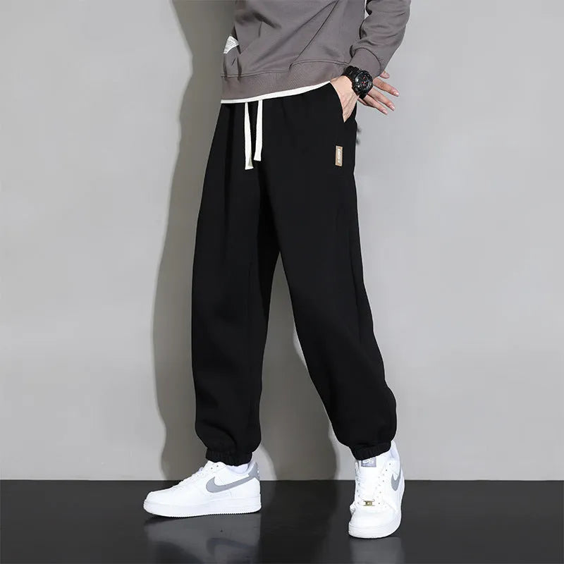 Men's loose grey cotton sports trousers with elastic waistband on hanger