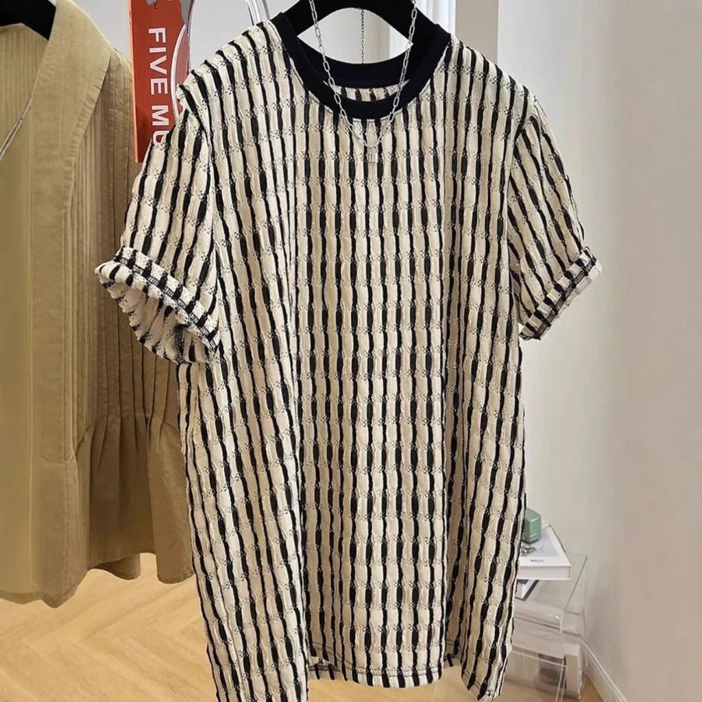 Men's black striped short-sleeve shirt with loose fit, made from linen and silk blend, shown in casual wear.