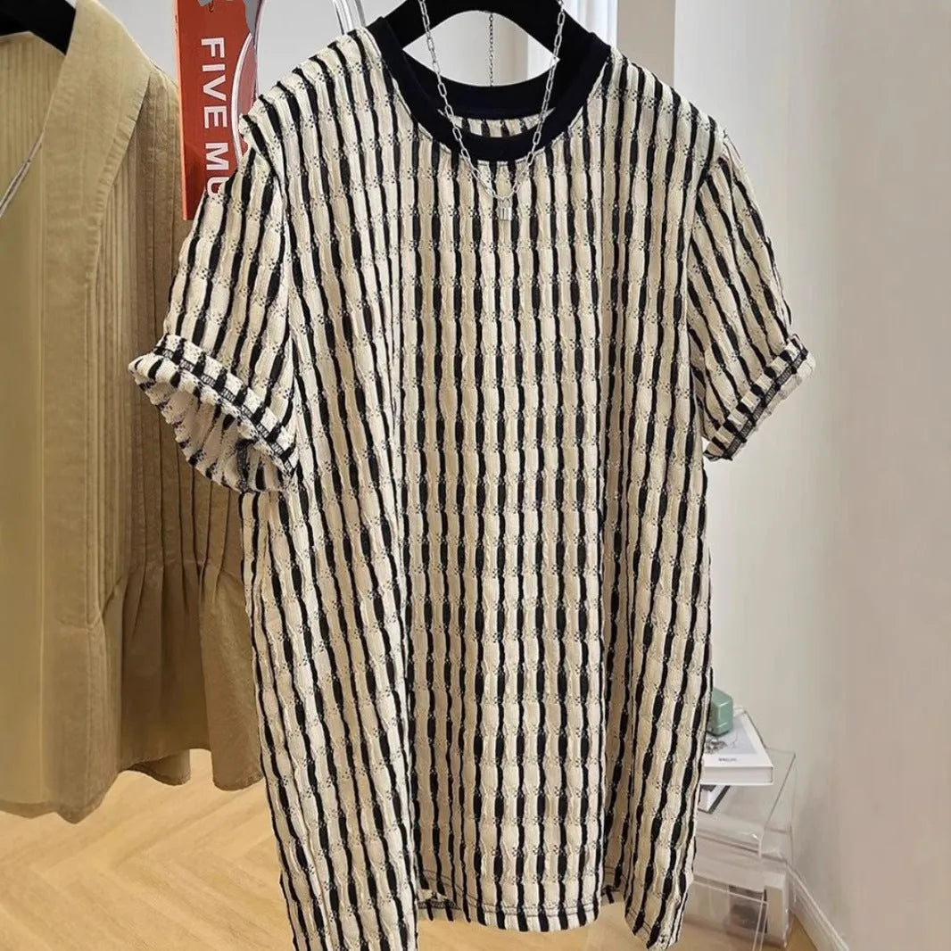 Men's black striped short-sleeve shirt with loose fit, made from linen and silk blend, shown in casual wear.