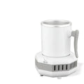 White portable aluminium quick-cooling cup and base on a desk next to a coffee mug.